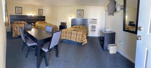 una camera con tre letti e un tavolo con sedie di Penn Amish Motel a Denver