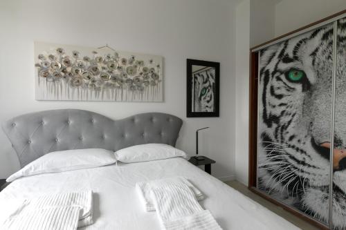 a bedroom with a white bed and a picture of a tiger at Un sogno sul lago Home Relax in Stresa