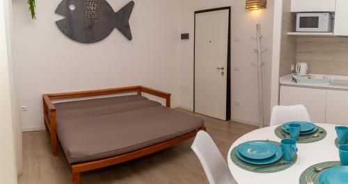 利多迪迪耶索洛的住宿－Casalina，小房间,配有床和一张桌子,上面有盘子