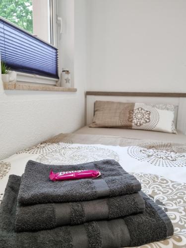 uma pilha de toalhas sentadas em cima de uma cama em Altstadt-FeWo-Freiberg em Freiberg