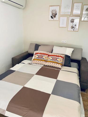 - un lit avec une couverture en damier et des oreillers dans l'établissement A l'ombre de l'Olivier, à LʼIsle-sur-la-Sorgue