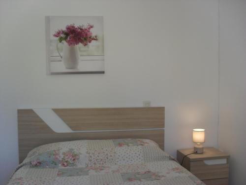 una camera da letto con un letto e un vaso di fiori sul muro di Monte dos Sabores a Lagos