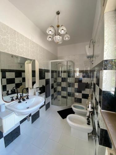 a bathroom with two sinks and a toilet and a chandelier at La Campanella in Manduria