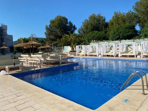 una piscina con sedie bianche e un resort di INN Mallorca Aparthotel a Magaluf