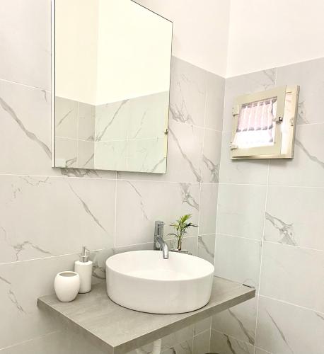 a white bathroom with a sink and a mirror at Casa Tortora in Santa Maria di Castellabate