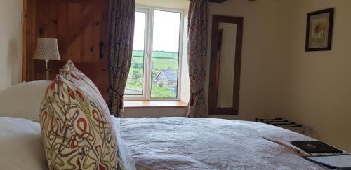 a bedroom with a large bed with a window at Middle Woodbatch B&B in Bishops Castle