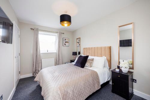 1 dormitorio con cama y espejo grande en City Centre -Perfect for Contractors & Families By Luxiety Stays Serviced Accommodation Southend on Sea, en Southend-on-Sea