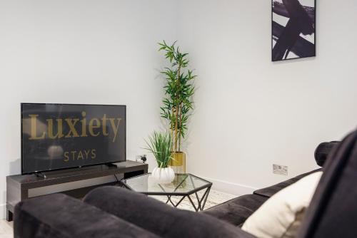 a living room with a couch and a tv at Stylish & Modern 1BR City Centre Nr the beach, High St & Adventure Island by Luxiety Stays in Southend-on-Sea