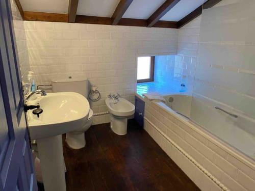 ein Badezimmer mit einem Waschbecken, einem WC und einer Badewanne in der Unterkunft La Casita in Cabezón de Liébana