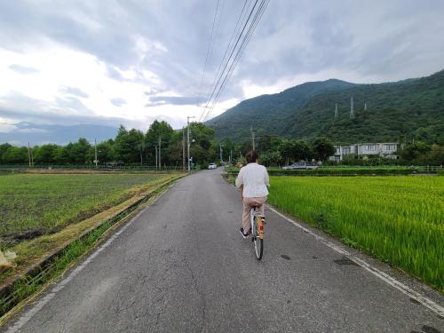 a man riding a bike down a road at Flower 280 in Jian