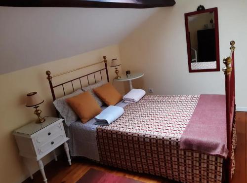 1 dormitorio con cama y espejo en la pared en Casa do Curral, en Negrões