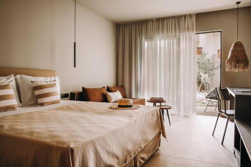 a bedroom with a large bed and a living room at Cook's Club Ialysos Rhodes in Ialyssos