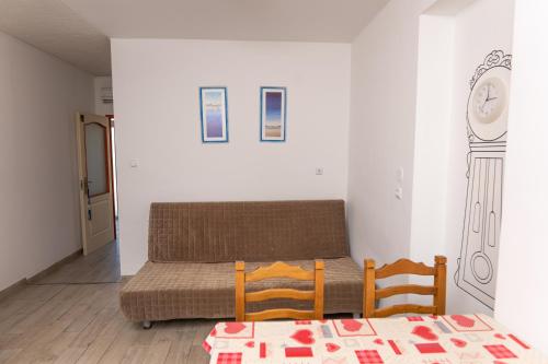 a couch in a room with a table and two chairs at Pelso Apartman in Zamárdi