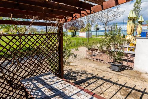 a fence in front of a yard with a fence at Pelso Apartman in Zamárdi