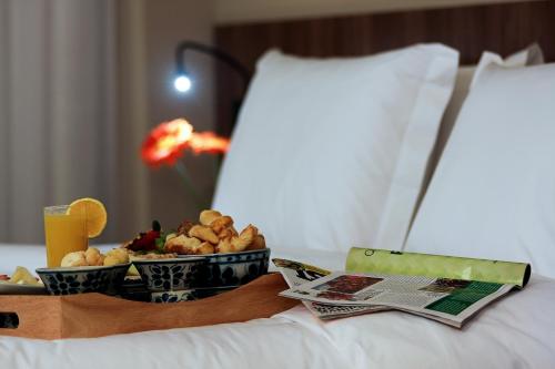 a tray of food on top of a bed at BH Raja Hotel in Belo Horizonte