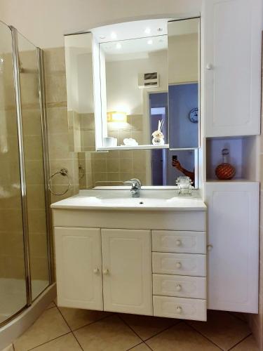 une salle de bain avec un lavabo blanc et une douche dans l'établissement Appartement traversant avec parking gratuit et navette gratuite plage à 2 mn à pied, à Cagnes-sur-Mer