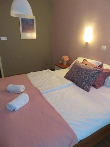 a bedroom with a large bed with two towels on it at Guesthouse ob Sotočju Budič in Brežice