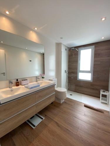 a bathroom with a sink and a toilet and a mirror at La Marina Sotogrande Pier2 in Torreguadiaro