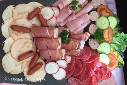 レーメにあるPension am Hochuferのソーセージとその他の肉や野菜の盛り合わせ