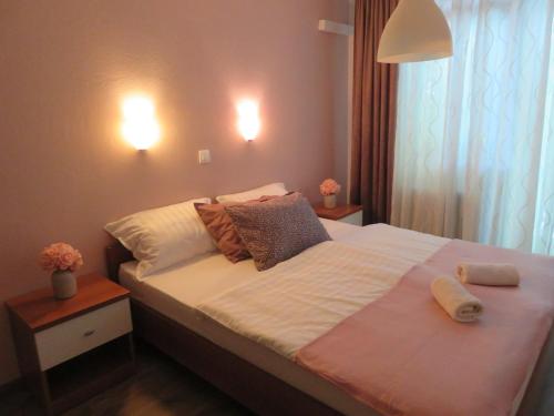 a bedroom with a bed with two towels on it at Guesthouse ob Sotočju Budič in Brežice