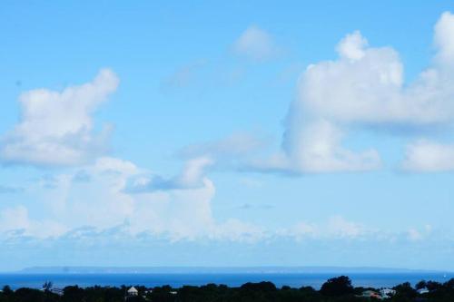 a cloudy sky with the ocean in the background at TI COIN RELAX bungalow vue mer piscine privée in Saint-François
