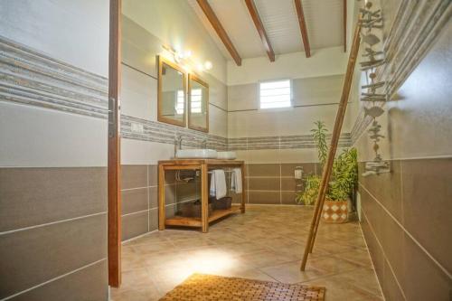 a bathroom with a sink and a mirror at TI COIN RELAX bungalow vue mer piscine privée in Saint-François