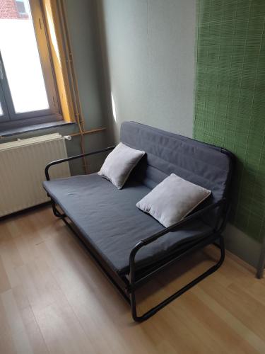 a bed in a room with two pillows on it at Studio indépendant accès direct autonome. in Le Cateau