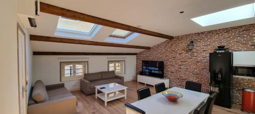 a living room with a brick wall at Loft 80m2 en plein cœur de la vieille ville 3 étoiles in Toulon