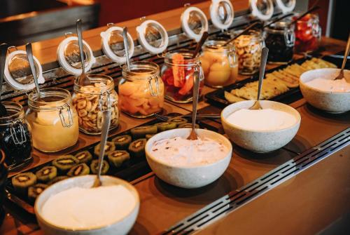 a buffet with bowls and jars of food and snacks at Cook's Club Ialysos Rhodes in Ialyssos