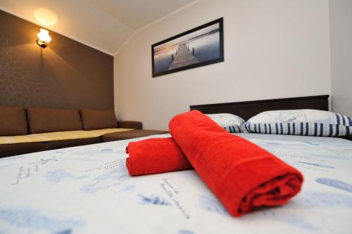 a red towel sitting on top of a bed at Apartments Bracic Spa in Sukošan