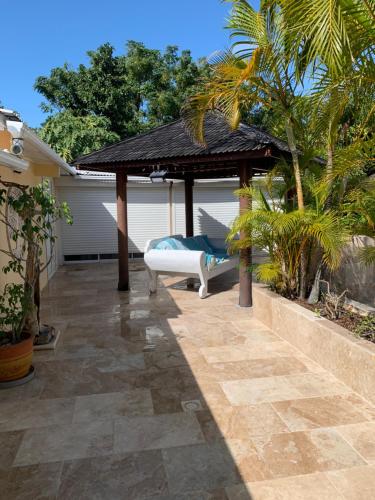 een patio met een prieel en een bed bij Lotus Garden - Île de la Réunion in Ravine des Cabris