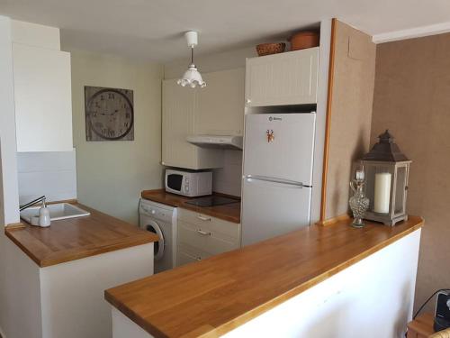 a kitchen with a white refrigerator and a counter top at Las mejores vistas del valle. Apartmento 65m.WIFI in Cerler