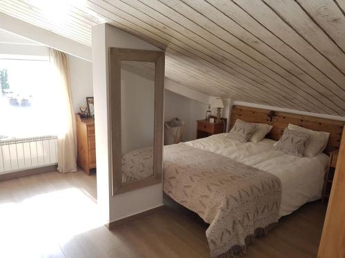 a bedroom with a large bed and a mirror at Las mejores vistas del valle. Apartmento 65m.WIFI in Cerler