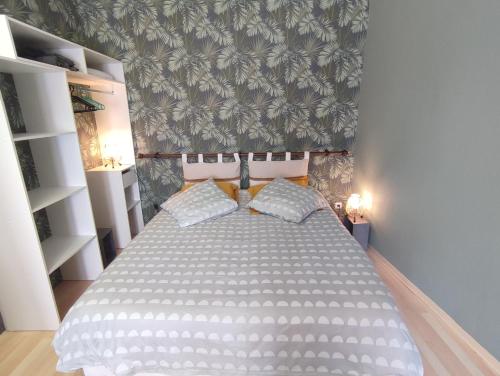 a bedroom with a large white bed with two pillows at Studio indépendant accès direct autonome. in Le Cateau