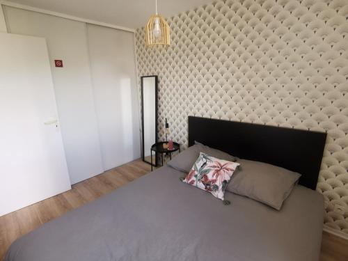 1 dormitorio con 1 cama grande y una gran pared acolchada en Cabourg T2 Front de Mer - Proche Thalasso, en Cabourg