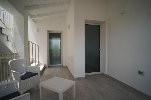 a hallway with a door and a table and chairs at Villa Lentischio in Budoni