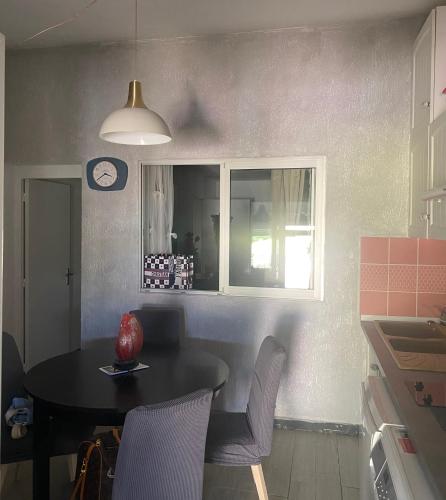 une cuisine avec une table, des chaises et une horloge dans l'établissement Maison Lolly corse wifii free, à Borgo