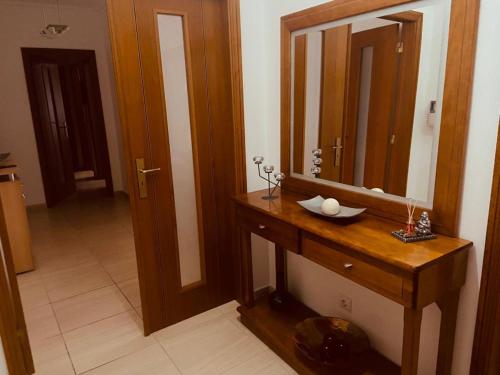 ein Badezimmer mit einem Waschtisch aus Holz und einem Spiegel in der Unterkunft Casa da Concha in Nazaré