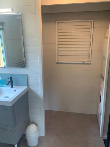 une salle de bain avec un lavabo, un miroir et une fenêtre dans l'établissement Le chalet de vacances, à Hermival-les-Vaux