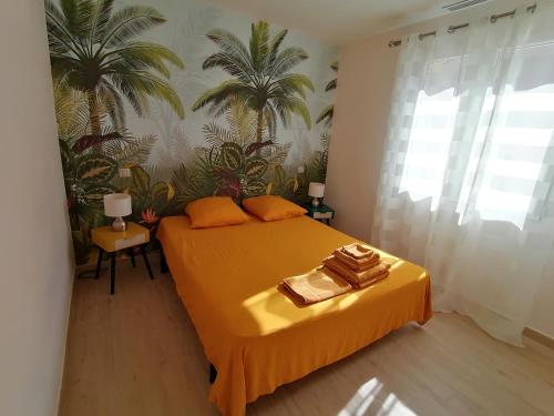 - une chambre avec un lit jaune et 2 serviettes dans l'établissement JULIANA, à Eyragues