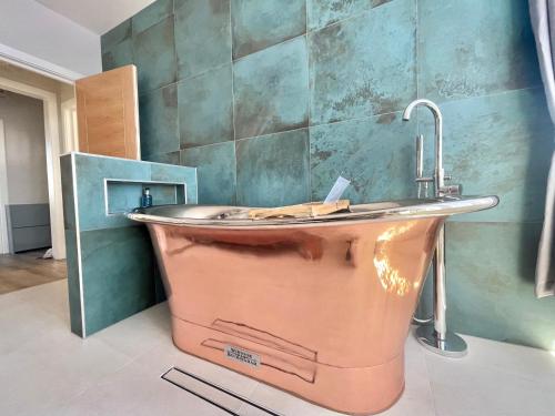 a large copper tub in a bathroom with a sink at Coastline Retreats - Stunning Balcony Apartment with Sea Views - Alice in Wonderland Themed Secret Room - Luxury Copper Bath in Master Bedroom in Southbourne