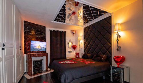 - une chambre avec un lit, une cheminée et une télévision dans l'établissement La Duchesse 1976, à Vernon