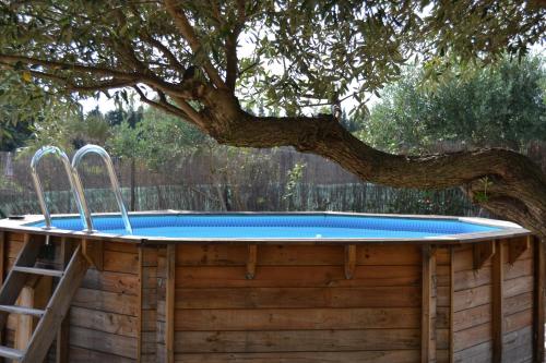 un bain à remous sur une terrasse en bois avec un arbre dans l'établissement Juste derrière chez nous, à Boulbon