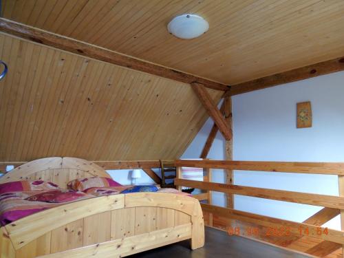 a wooden bed in a room with a wooden ceiling at Gdzie diabeł mówi dobranoc in Pisz