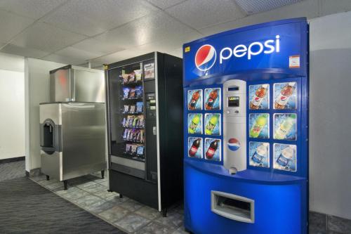 a pepsi soda machine in a store next to a refrigerator at Motel 6-Lakeville, MN - South - Lakeville in Lakeville