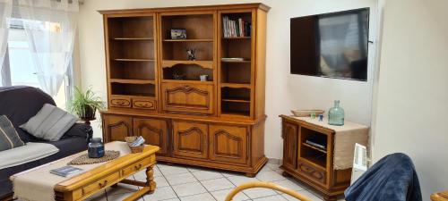 a living room with a large wooden entertainment center at TI BIHAN TIEGUEZH in Île de Batz