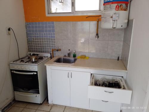 cocina pequeña con fregadero y fogones en Alojamiento económico de buena ubicación en Gualeguaychú
