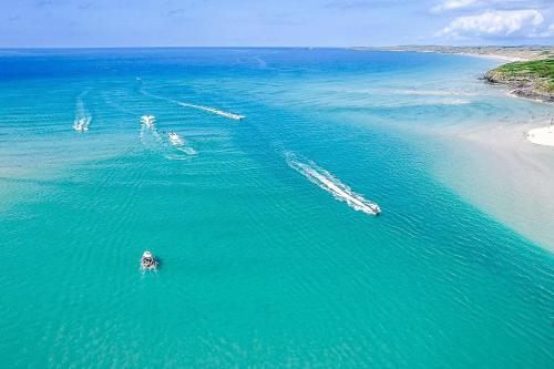 a group of boats in the water near a beach at Loggans Lodge in Hayle