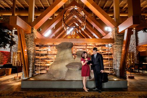 a man and a woman standing in front of a statue at Sawridge Inn and Conference Centre Edmonton South in Edmonton