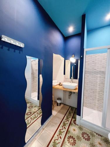 a blue bathroom with a sink and a mirror at DEAS B&B in Trani